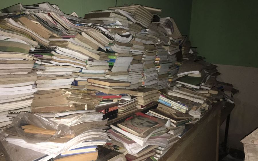 Sede da associação abandonada, com acervo de livros arruinados empilhados